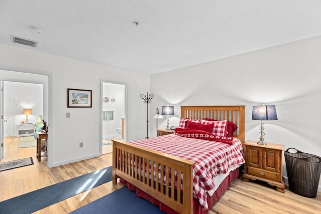 bedroom featuring light wood-type flooring and ensuite bathroom