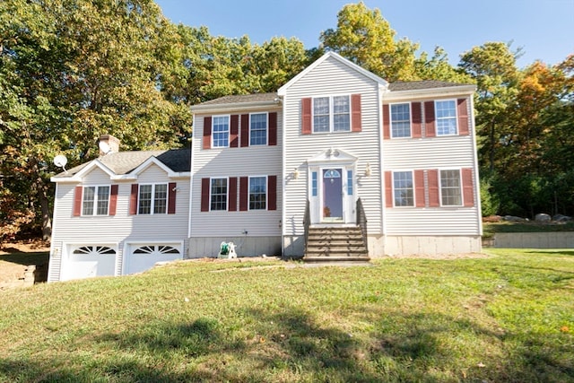 colonial house featuring a garage and a front lawn