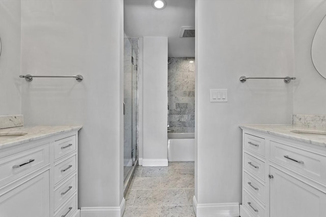 full bath featuring a sink, a stall shower, baseboards, and two vanities