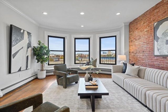 living area featuring brick wall, a baseboard radiator, ornamental molding, and wood finished floors