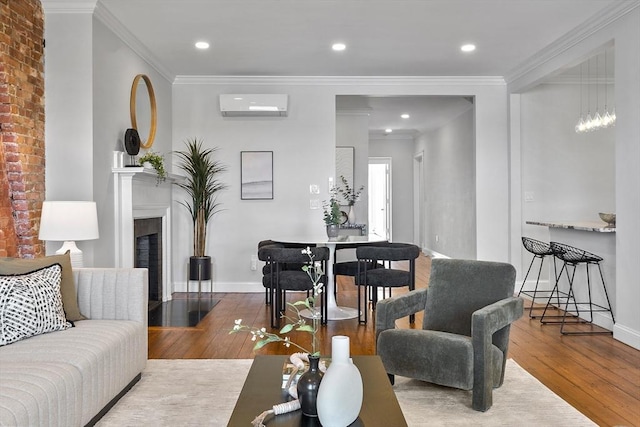 living room featuring wood-type flooring, a wall unit AC, crown molding, and a fireplace