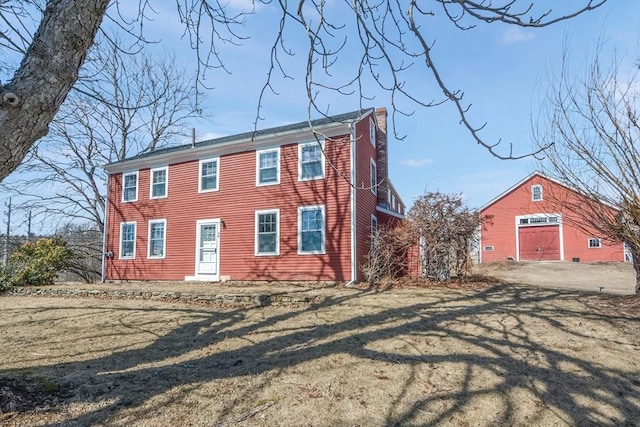 colonial home with a front yard and an outbuilding