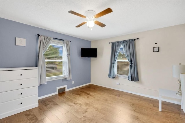 122 Brookside Cir, Springfield, MA 01129 - unfurnished bedroom with multiple windows, wood finished floors, a ceiling fan, and a textured ceiling