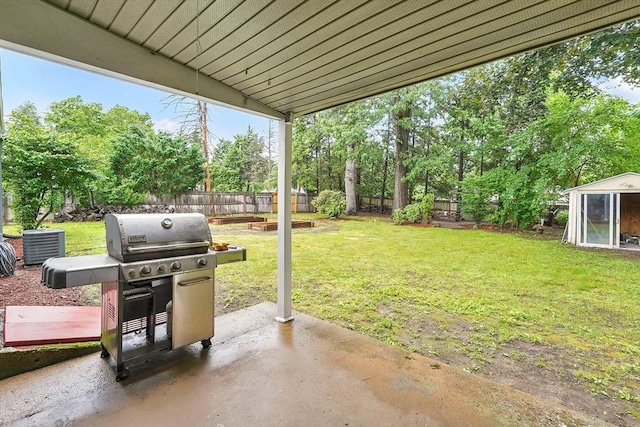 122 Brookside Cir, Springfield, MA 01129 - fenced backyard featuring a patio, view of wooded area, and a storage unit