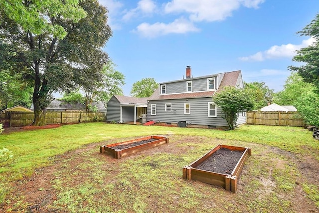 122 Brookside Cir, Springfield, MA 01129 - rear view of property featuring a vegetable garden, a fenced backyard, crawl space, and a chimney