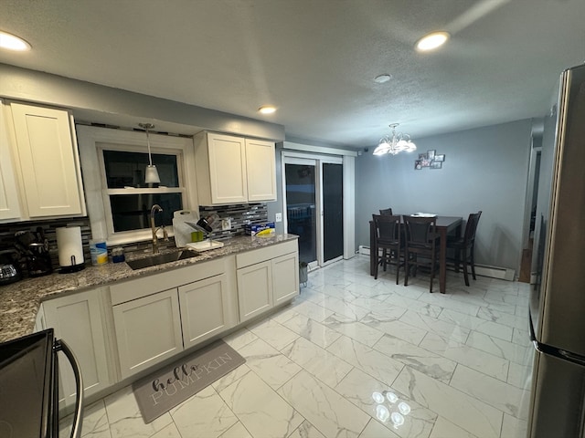 kitchen featuring sink, white cabinetry, decorative backsplash, stainless steel appliances, and decorative light fixtures