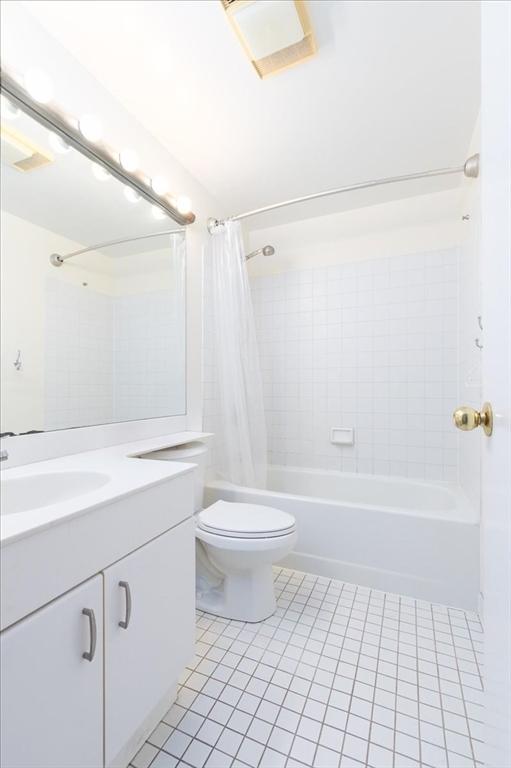 full bath featuring vanity, tile patterned floors, shower / bath combination with curtain, and toilet