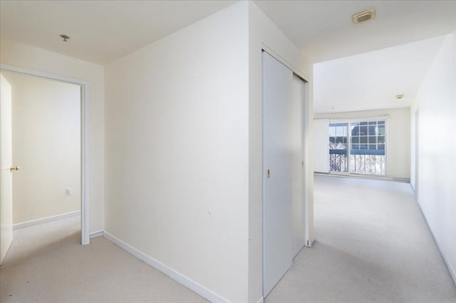 hall with light colored carpet