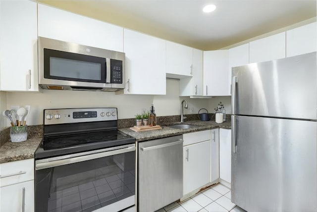 kitchen with white cabinets, light tile patterned floors, appliances with stainless steel finishes, and a sink