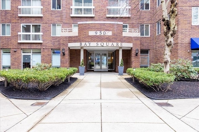 property entrance featuring brick siding and french doors