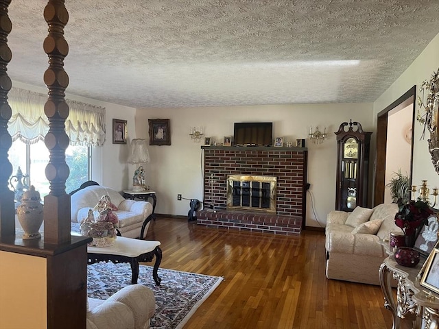 living area featuring baseboards, a textured ceiling, wood finished floors, and a fireplace