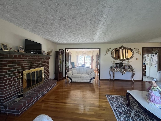 living room with baseboards, a textured ceiling, wood finished floors, and a fireplace