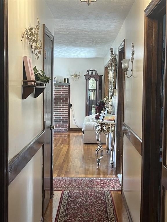 hallway featuring a textured ceiling and wood finished floors