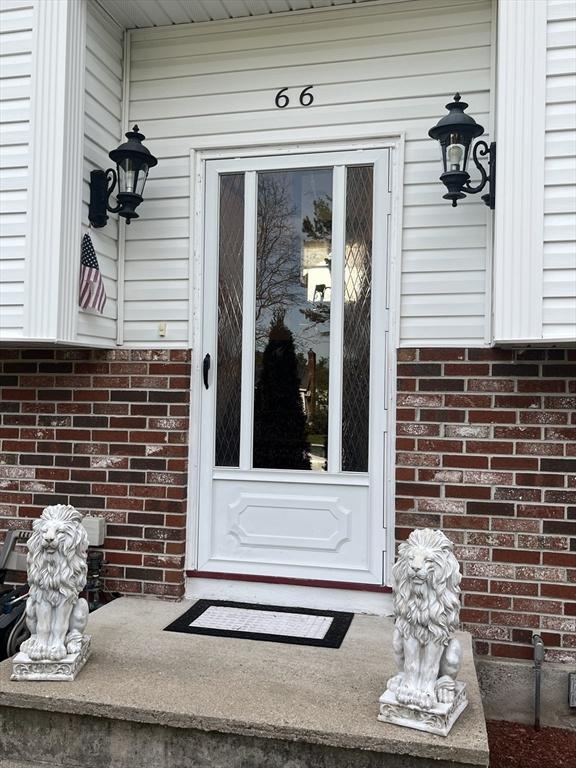 entrance to property featuring brick siding