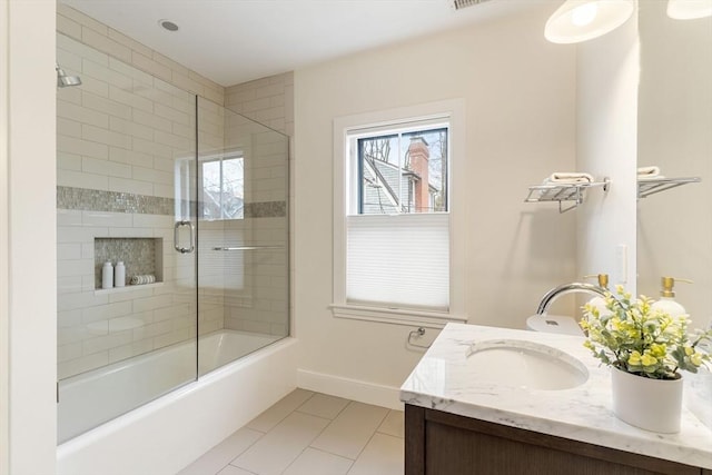 full bath featuring tile patterned flooring, baseboards, combined bath / shower with glass door, and vanity