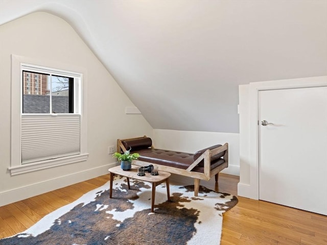 interior space with vaulted ceiling, baseboards, and light wood-style floors