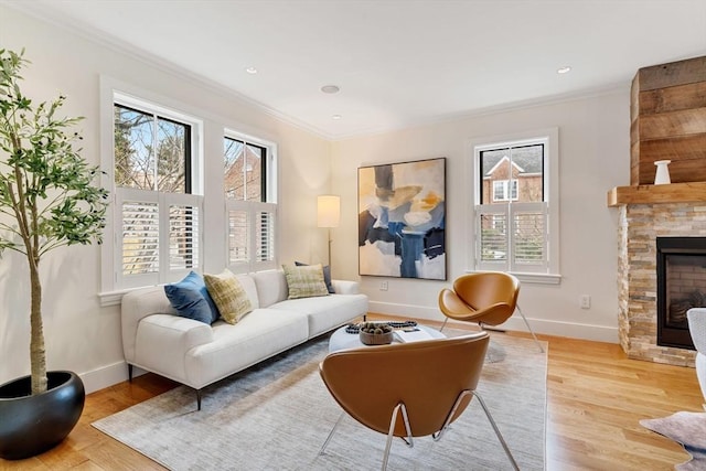 living area featuring ornamental molding, plenty of natural light, a fireplace, and baseboards