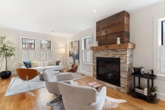 living area with a healthy amount of sunlight, light wood-style flooring, and crown molding