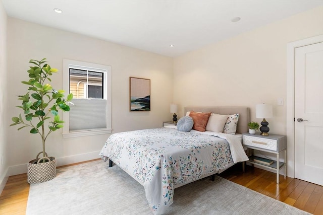 bedroom with baseboards, wood finished floors, and recessed lighting