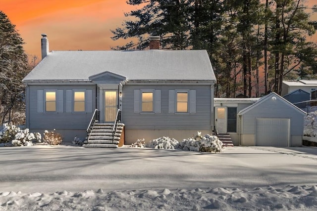 view of front of home with a garage and an outbuilding