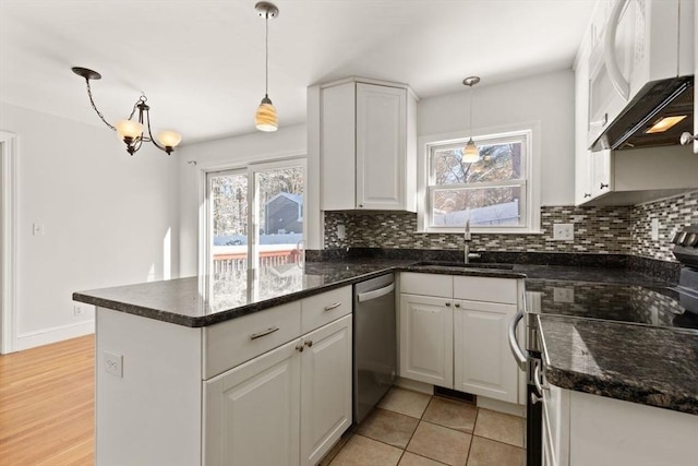 kitchen with white cabinetry, stainless steel appliances, decorative light fixtures, and kitchen peninsula