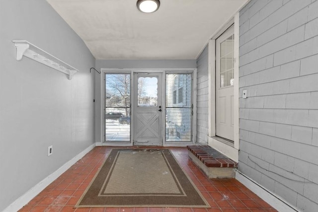 entryway featuring dark tile patterned flooring and vaulted ceiling