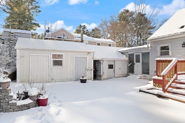 view of snow covered back of property