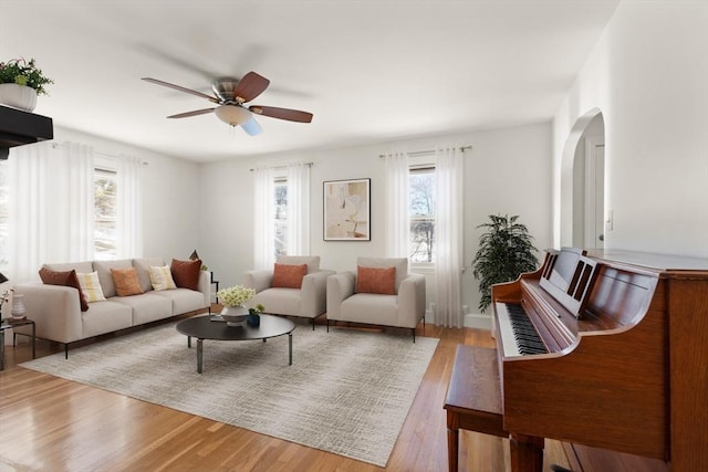 living room with ceiling fan, a healthy amount of sunlight, and light wood-type flooring