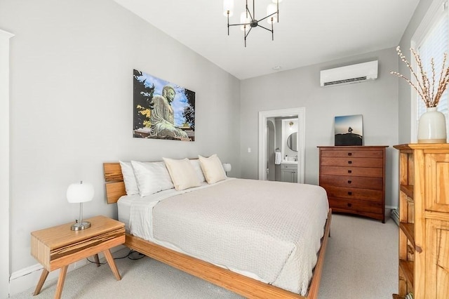 bedroom featuring an AC wall unit, a notable chandelier, and ensuite bathroom