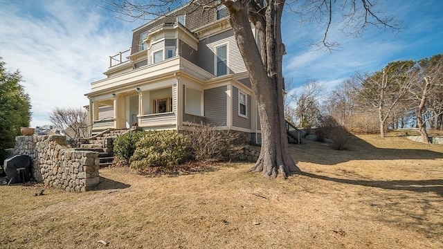 view of property exterior featuring mansard roof and covered porch