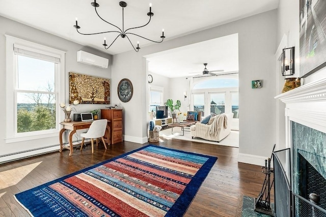 living area with baseboard heating, wood finished floors, a tiled fireplace, and a wall mounted AC