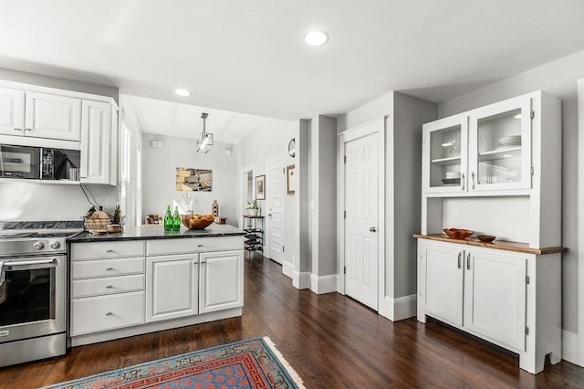 kitchen with glass insert cabinets, black microwave, stainless steel range with gas stovetop, dark wood-style floors, and white cabinets