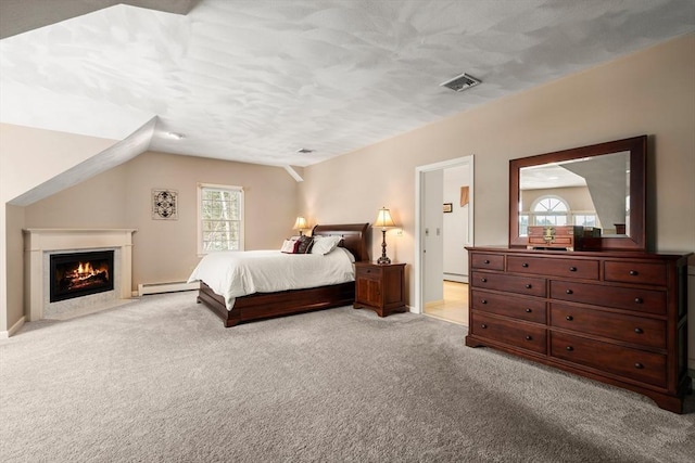 carpeted bedroom with vaulted ceiling, a fireplace with flush hearth, visible vents, and baseboard heating