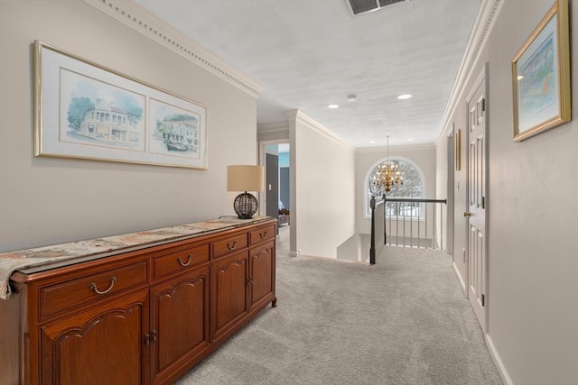 hallway with visible vents, an inviting chandelier, crown molding, an upstairs landing, and light colored carpet