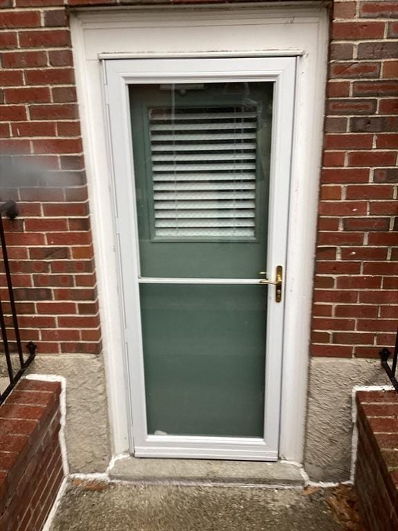 property entrance featuring brick siding