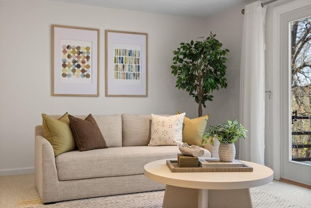 living area with a healthy amount of sunlight, baseboards, and light carpet