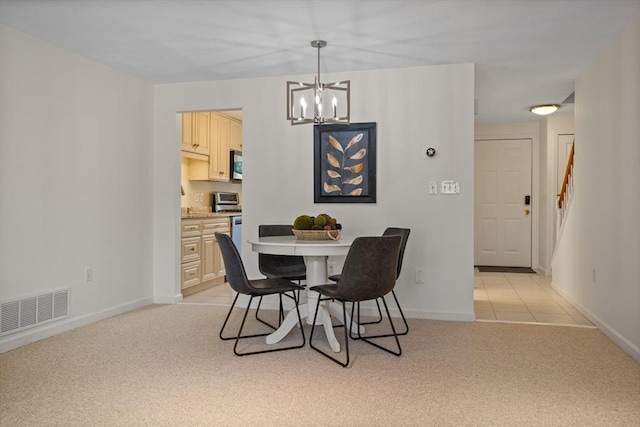 dining space featuring a chandelier, baseboards, visible vents, and light carpet