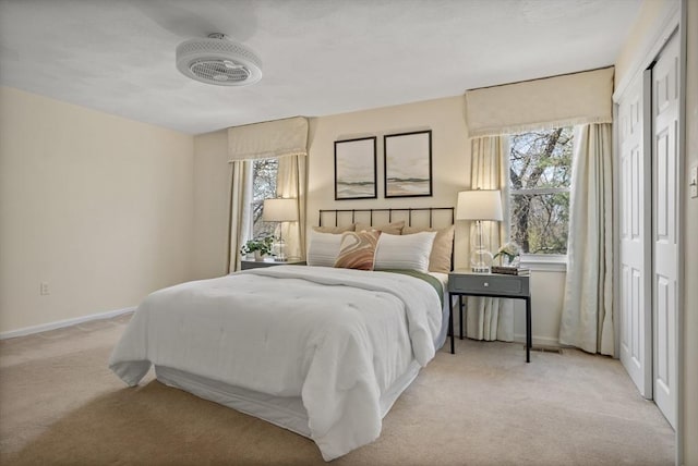 bedroom with light colored carpet and baseboards