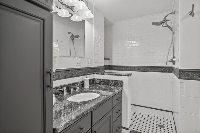 bathroom with vanity, tiled shower, and tile walls