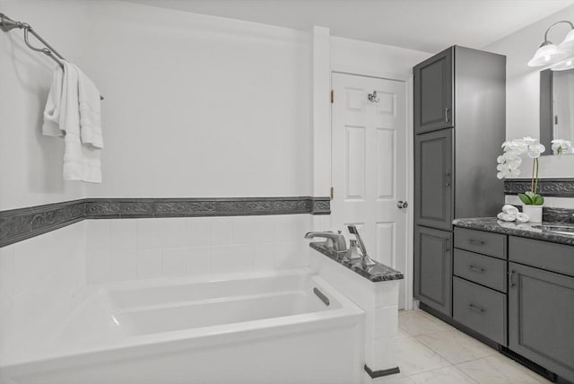 bathroom with marble finish floor, a garden tub, and vanity
