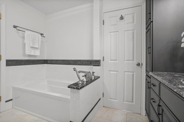 full bathroom featuring vanity, marble finish floor, and a bath