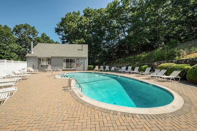 community pool featuring fence and a patio