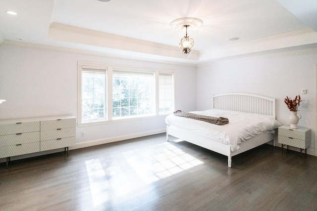 bedroom with baseboards, ornamental molding, a raised ceiling, and dark wood-style flooring