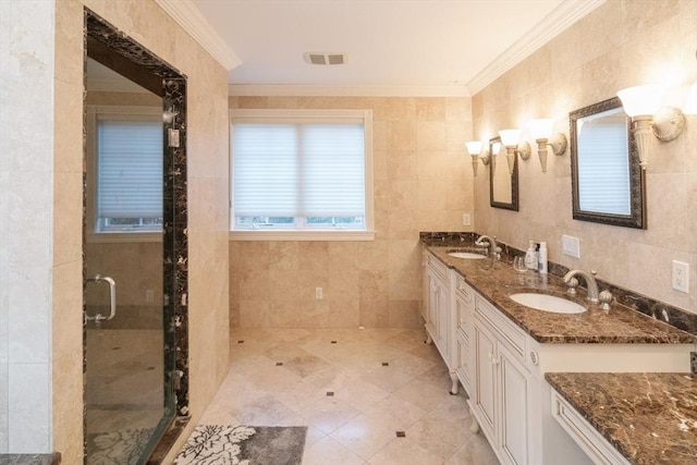 bathroom with a sink, visible vents, tile walls, ornamental molding, and a shower stall