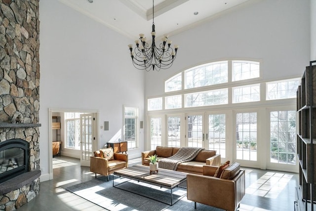 living room with a wealth of natural light, french doors, and a stone fireplace