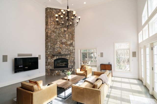 living area featuring a stone fireplace, ornamental molding, a high ceiling, and baseboards