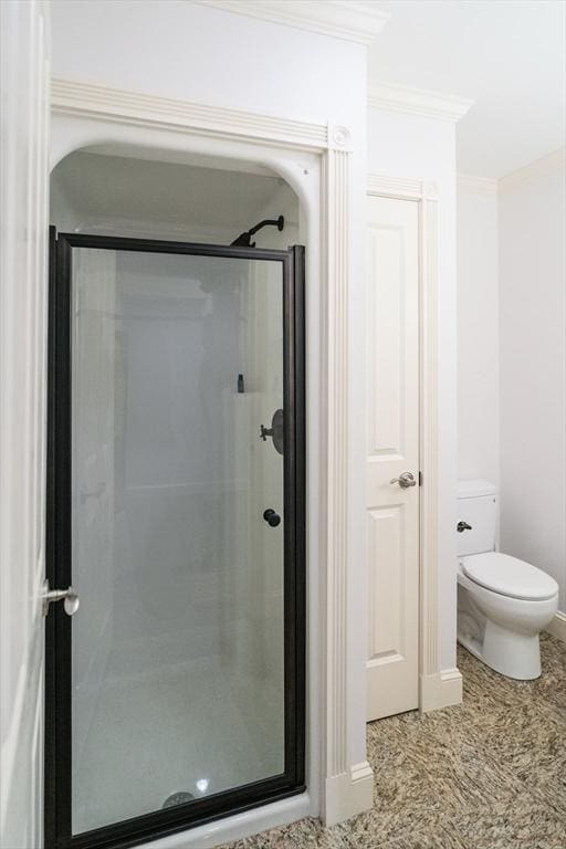 full bath featuring a stall shower, toilet, and crown molding