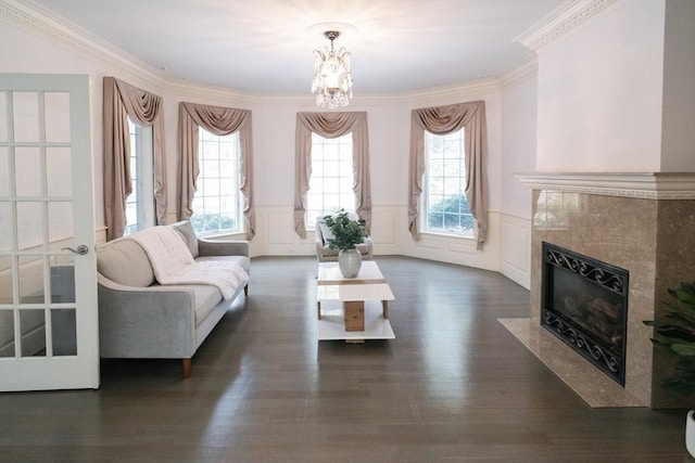 living area featuring a wealth of natural light, a high end fireplace, wainscoting, and dark wood-style floors