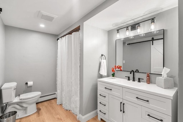 9 Indian Rock Dr, Saugus, MA 01906 - full bath featuring a baseboard heating unit, toilet, wood finished floors, vanity, and a shower with shower curtain