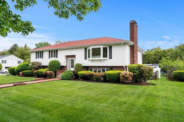 9 Indian Rock Dr, Saugus, MA 01906 - split foyer home featuring a chimney, a front lawn, and brick siding